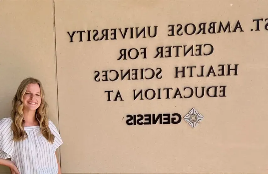 A woman standing next to a sign titled 